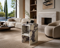 Modern living room with beige sofa, marble side table, and fireplace.